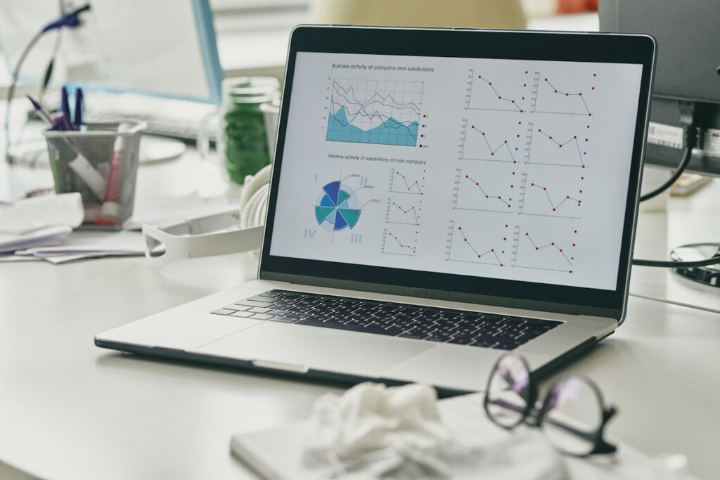 Financial graphs and diagram on display of laptop on workplace of broker